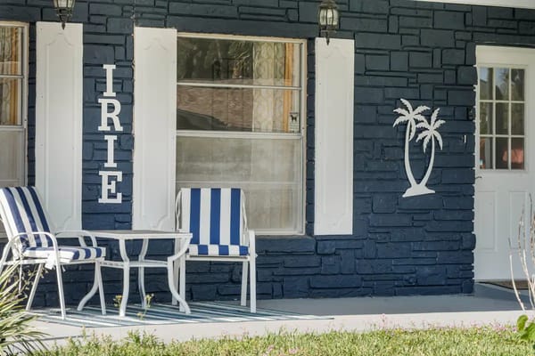 Front porch area with blue walls and striped chairs.