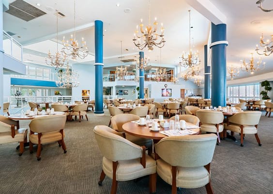 Spacious dining area with round tables and chandeliers