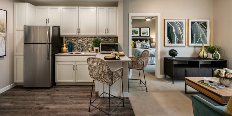 Bright kitchen and living area in a senior living facility with stylish decor.