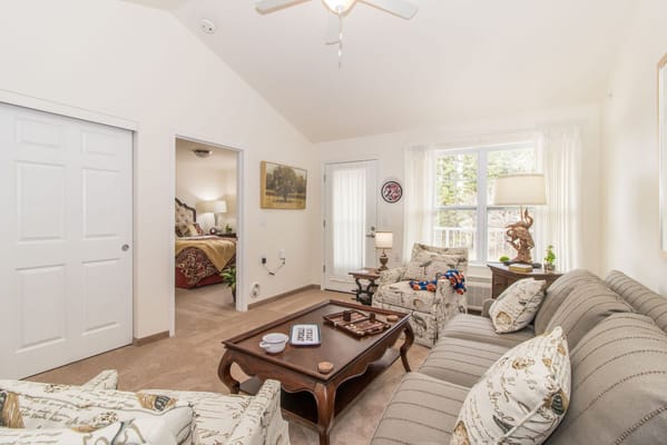 Living room with comfortable seating, coffee table, and doorway to bedroom.