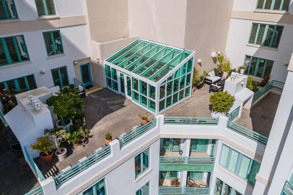 Aerial view of a glass greenhouse and landscaped patio at The Stratford.