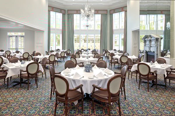 Dining room with elegant round tables and chairs at The Tradition