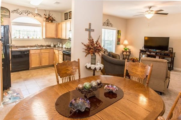 Dining table with decorative items and a view of the kitchen and living area.