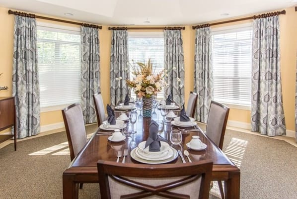 Elegant dining room set for a meal with flowers and tableware.