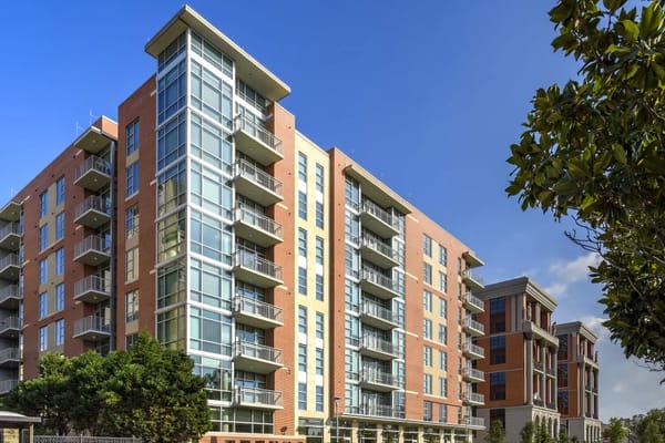 Modern senior living facility with glass balconies and brick facade