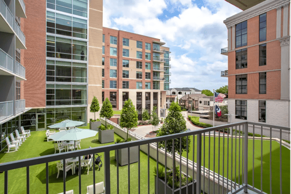 View of the courtyard from a balcony featuring greenery and seating areas.