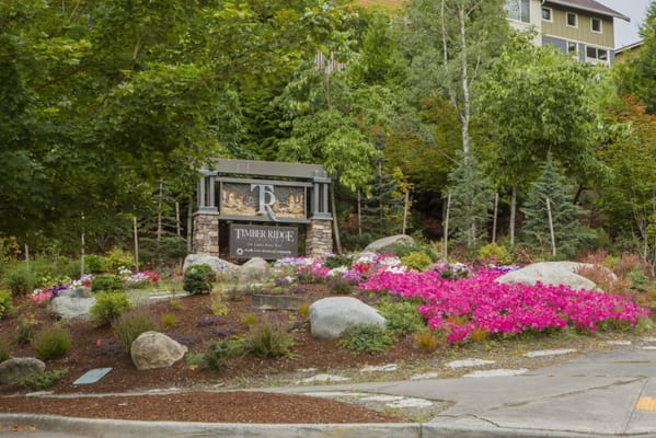 Entrance sign of Timber Ridge senior living facility surrounded by flowers
