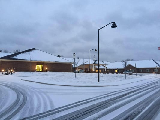 Exterior view of Trinity Elms Health and Rehab building covered in snow