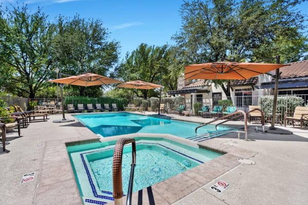 Outdoor pool area with lounge chairs and umbrellas