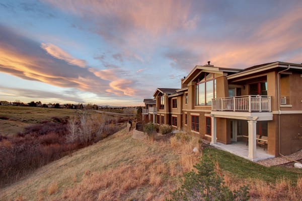 Exterior view of Vi at Silverstone featuring lush landscaping under a colorful sky.