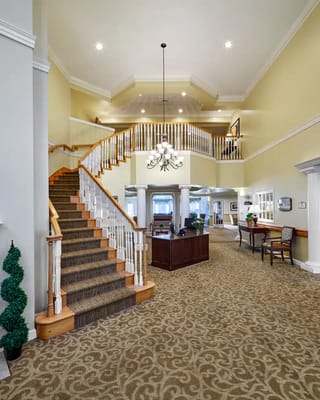 Wide view of the lobby with a staircase and chandelier