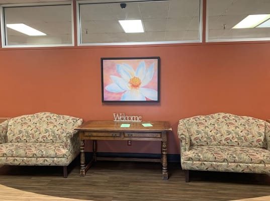 Cozy lobby area with floral sofas and a welcome sign