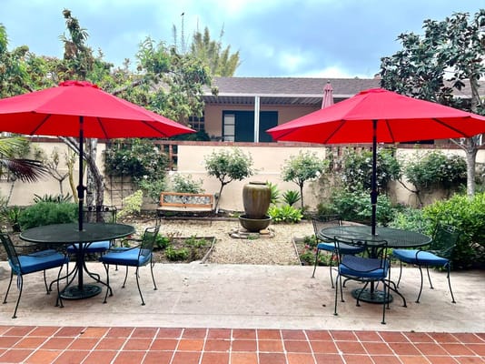 A peaceful outdoor seating area with red umbrellas
