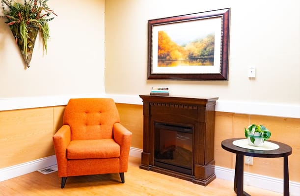 Cozy lounge area with an orange chair and wall art