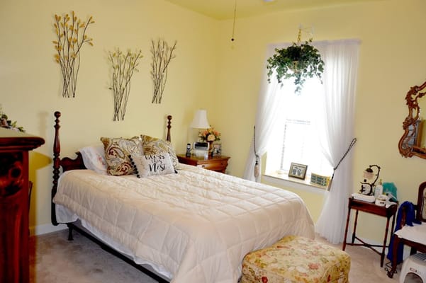 A cozy bedroom with a bed, decorative pillows, and soft lighting