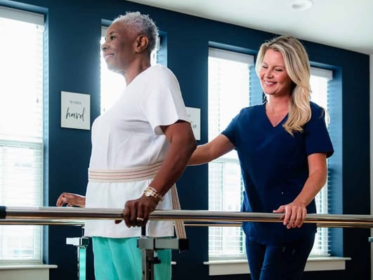 A staff member assisting a resident during therapy
