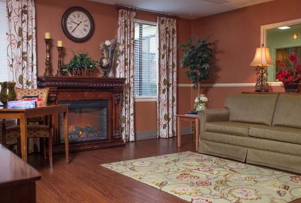 Common area of a senior living facility with fireplace and seating