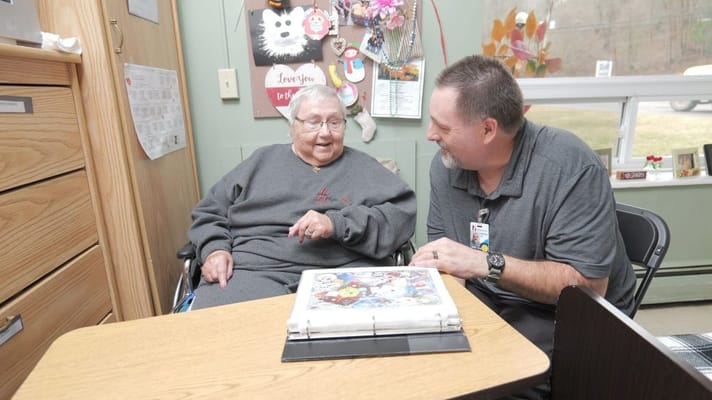 Resident engaging with staff member in a cozy room