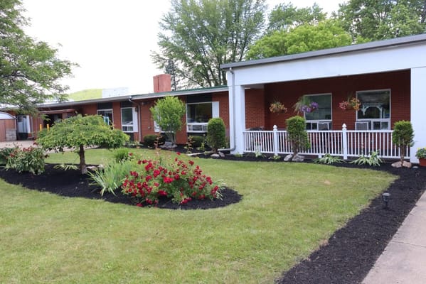 Exterior view of Highland Park Rehabilitation & Nursing Center with gardens