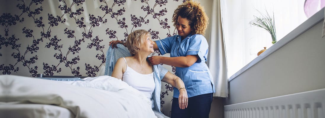 Caregiver assisting a resident in a bright room