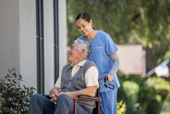 Caregiver assisting a resident outdoors