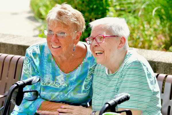 Two women enjoying time outdoors on a bench