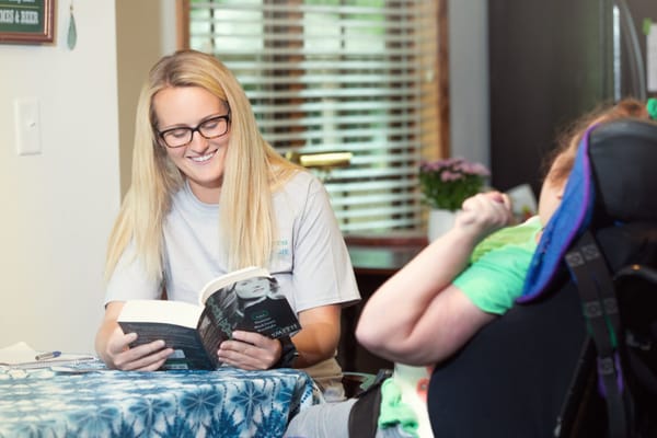 Staff member reading to a resident in a comfortable setting