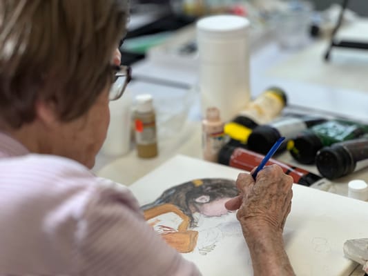 Senior resident painting in an art class