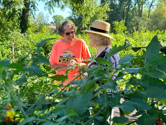 Two residents interacting in a lush garden