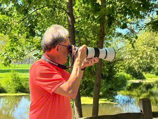A resident photographing nature by a pond