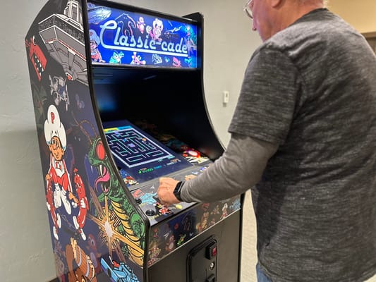 Resident playing a retro arcade game in the activity room