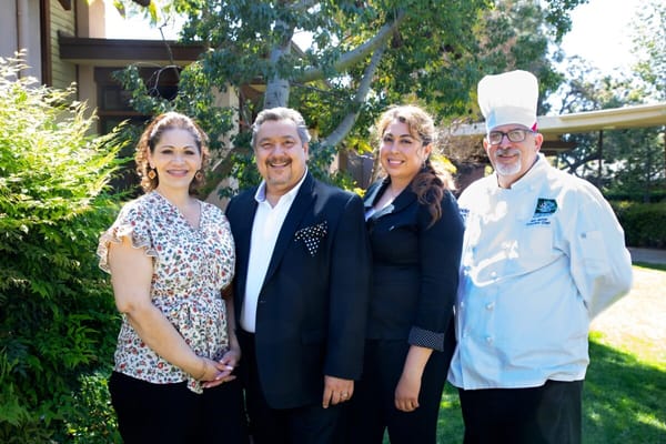Staff members posing outdoors near the facility