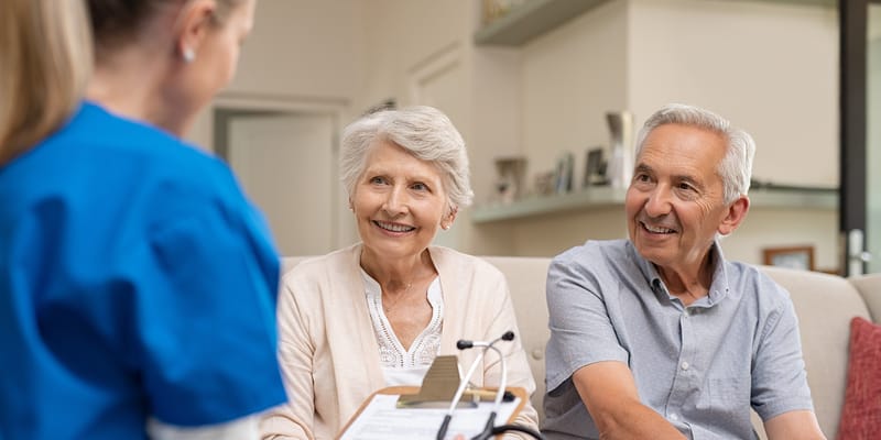 Residents chatting with a staff member in a cozy common area