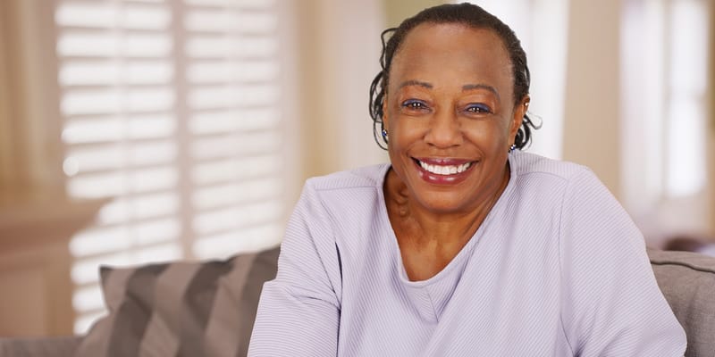 A smiling resident in a cozy interior space