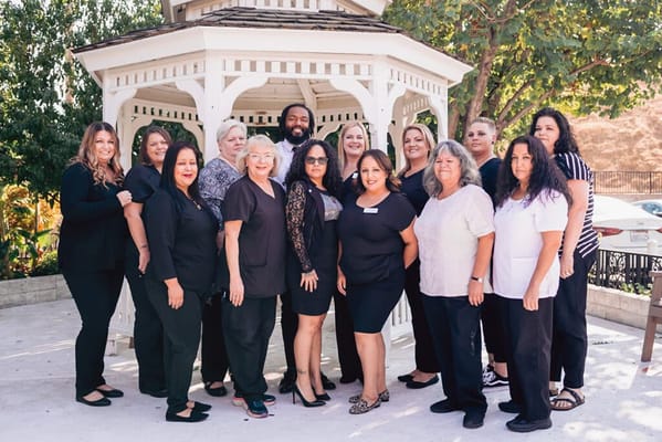 Group of staff members posing outside near a gazebo