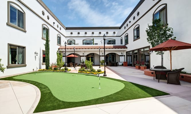 Outdoor courtyard with synthetic grass and seating areas