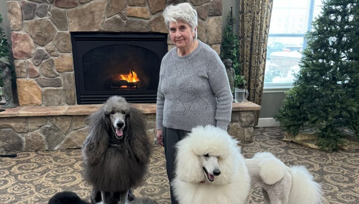 Resident with poodles in a cozy common area