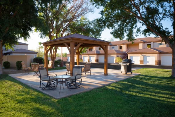 Outdoor seating area with gazebo and green space