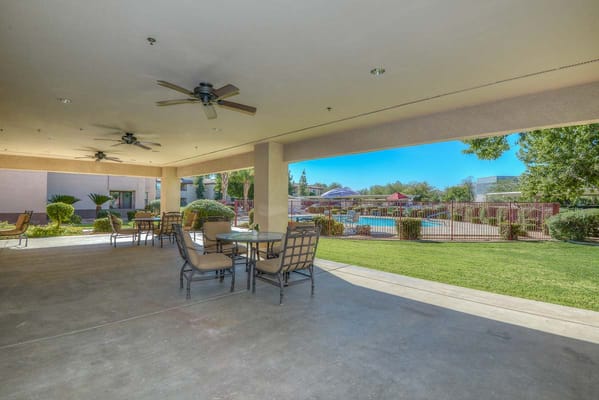 Outdoor patio area with furniture overlooking a pool