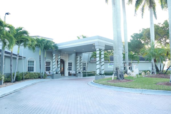 Front entrance of HarborChase of Coral Springs with palm trees