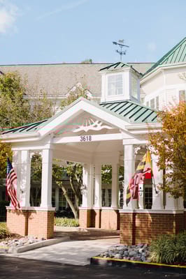 Entrance of a senior living facility with flags