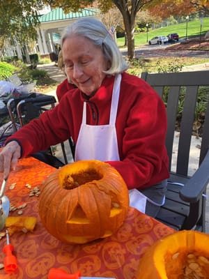 Resident enjoying pumpkin carving outdoors