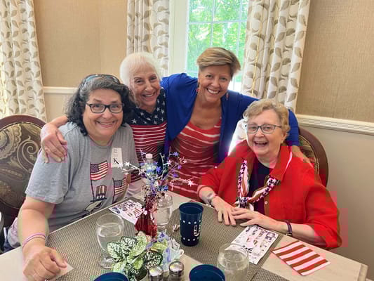 Four residents celebrating together in a colorful room