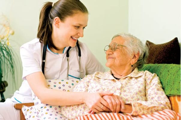A caregiver smiling with a resident in a cozy room