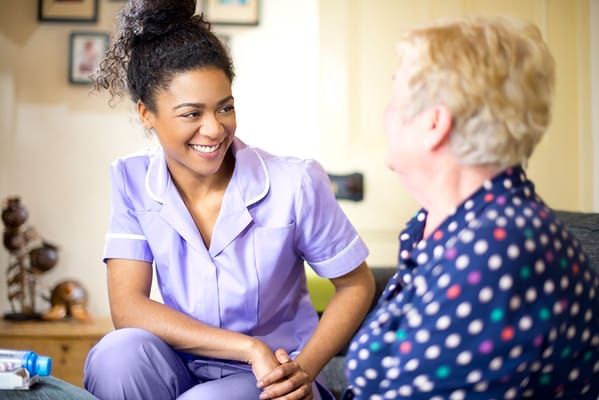 Caregiver smiling and interacting with a resident.