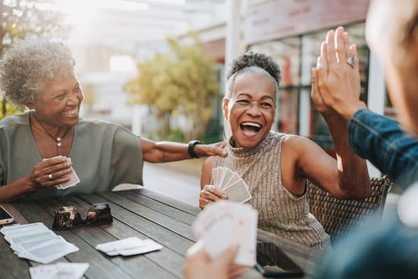Residents playing cards outdoors and enjoying each other's company