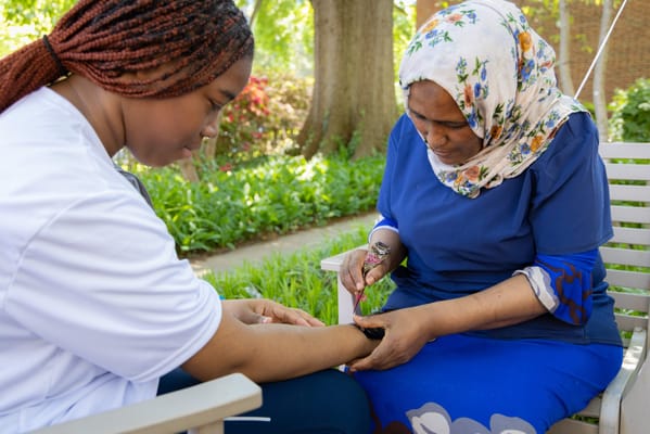A staff member assisting a resident outdoors in a garden