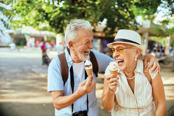 Two seniors enjoying ice cream at an outdoor fair