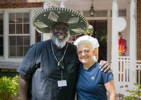 Two residents smiling together outdoors at a celebration