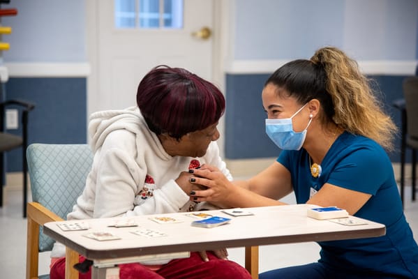 Staff assisting a resident in a social activity